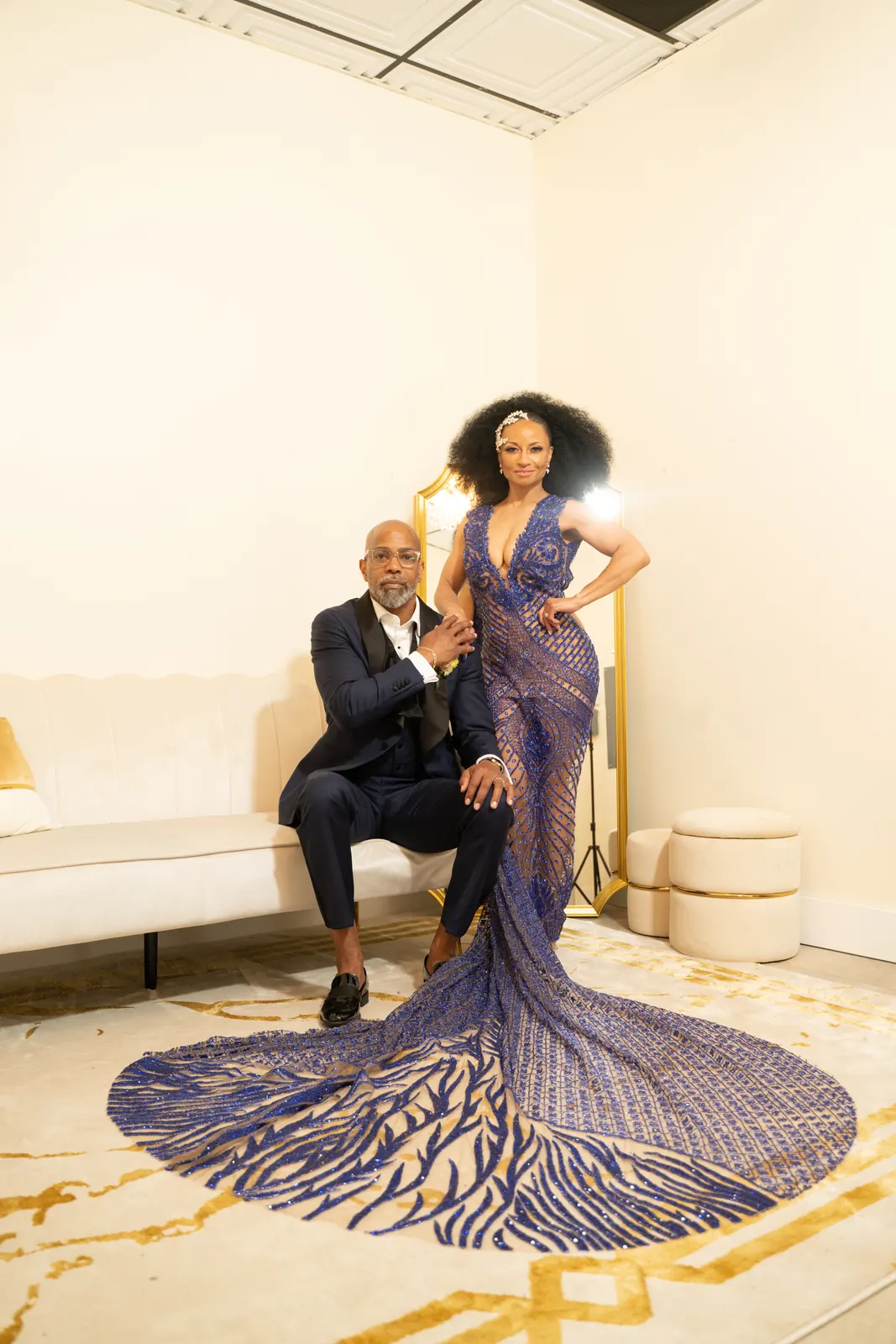 Couple posing in a marble foyer, bride in a sequined purple gown with a long train